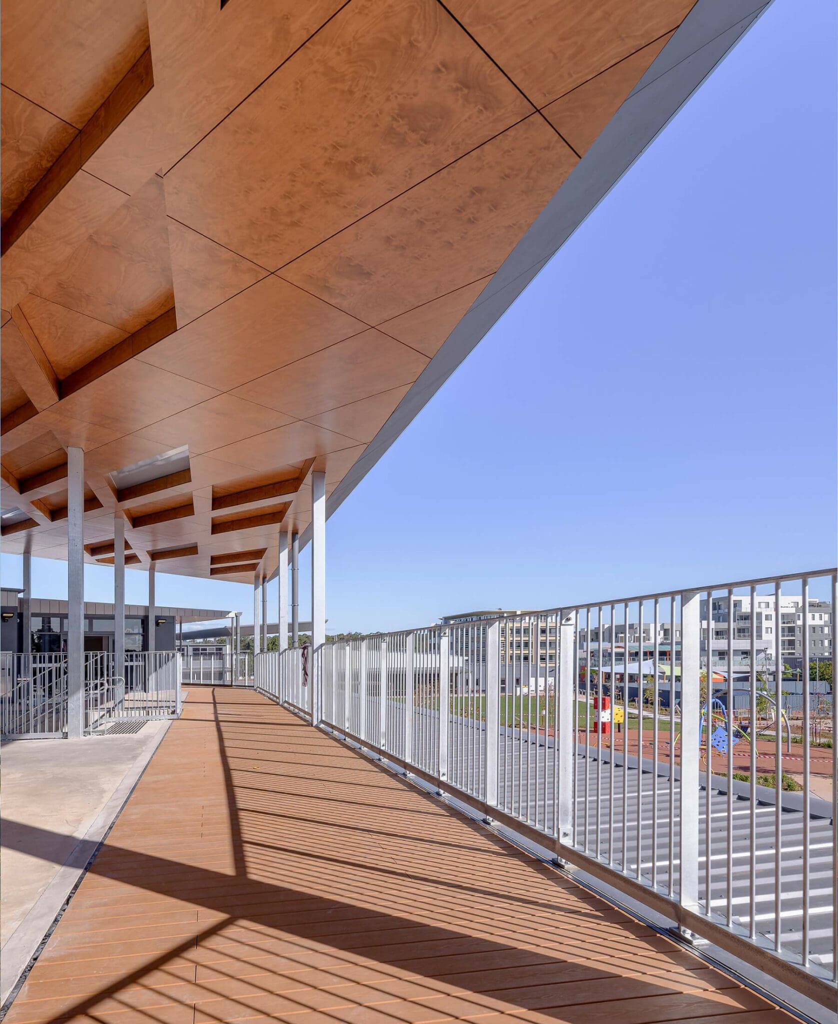 a walkway with a railing and a building