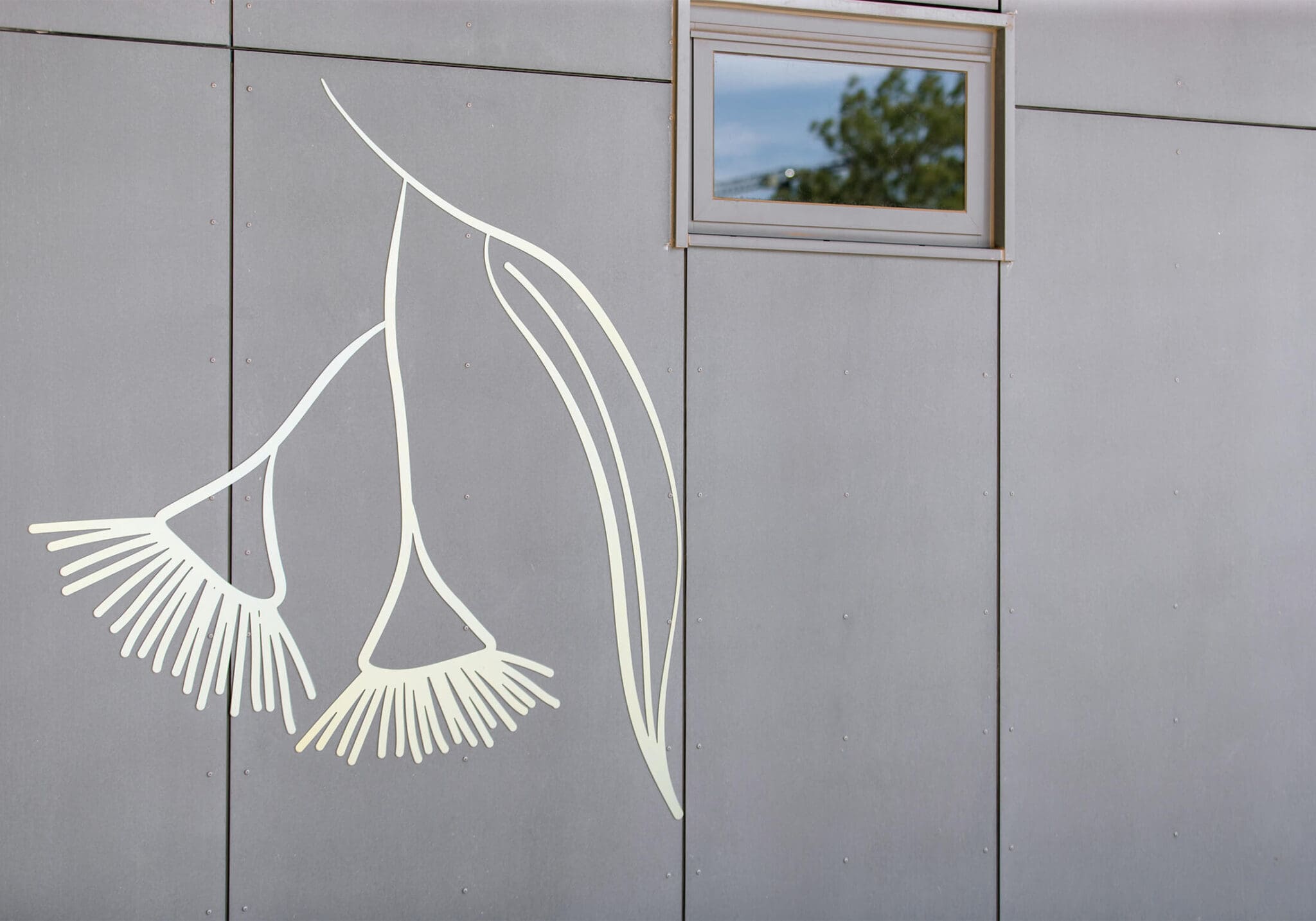 a grey wall with a window and a drawing of a plant