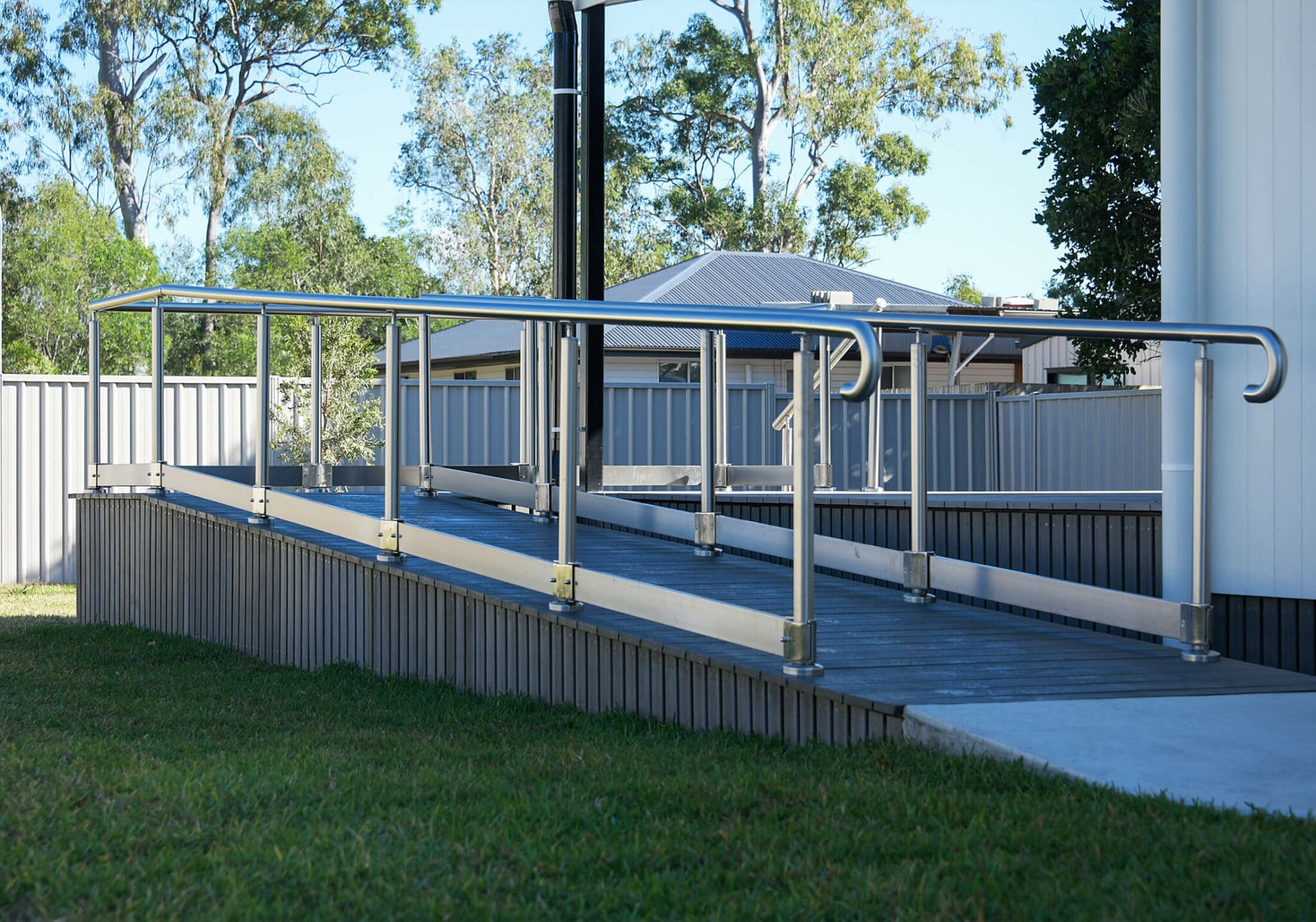 a ramp with metal railings and grass